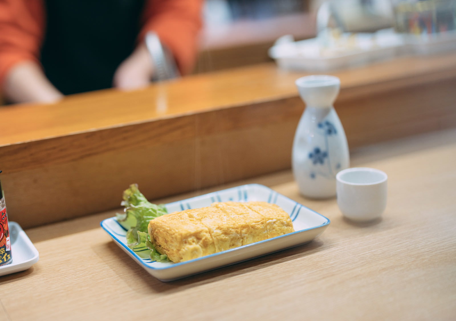 Finished tamagoyaki served on a plate at a Japanese restaurant counter
